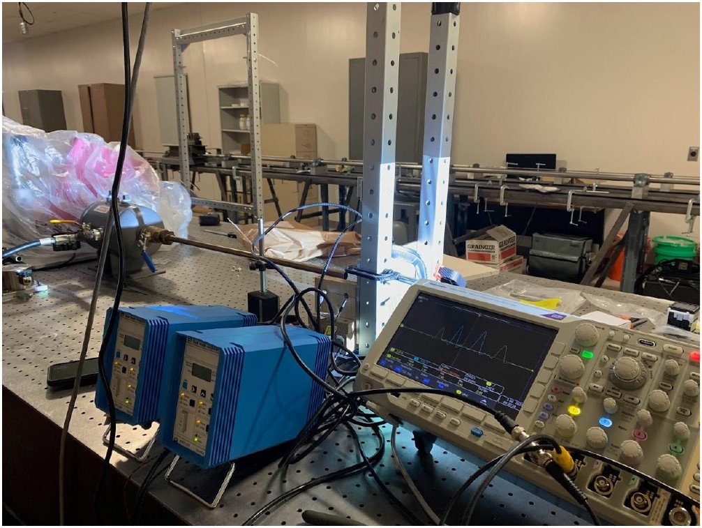 Gas gun barrel, strain gauge amplifiers, and Tektronix oscilloscope capturing impact waveforms