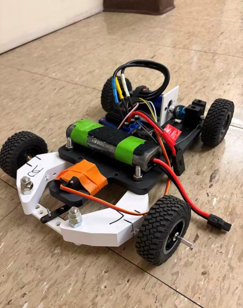 Assembled belt-driven RC car with 3D-printed white front chassis, black rear chassis, green LiPo battery, servo, and ESC